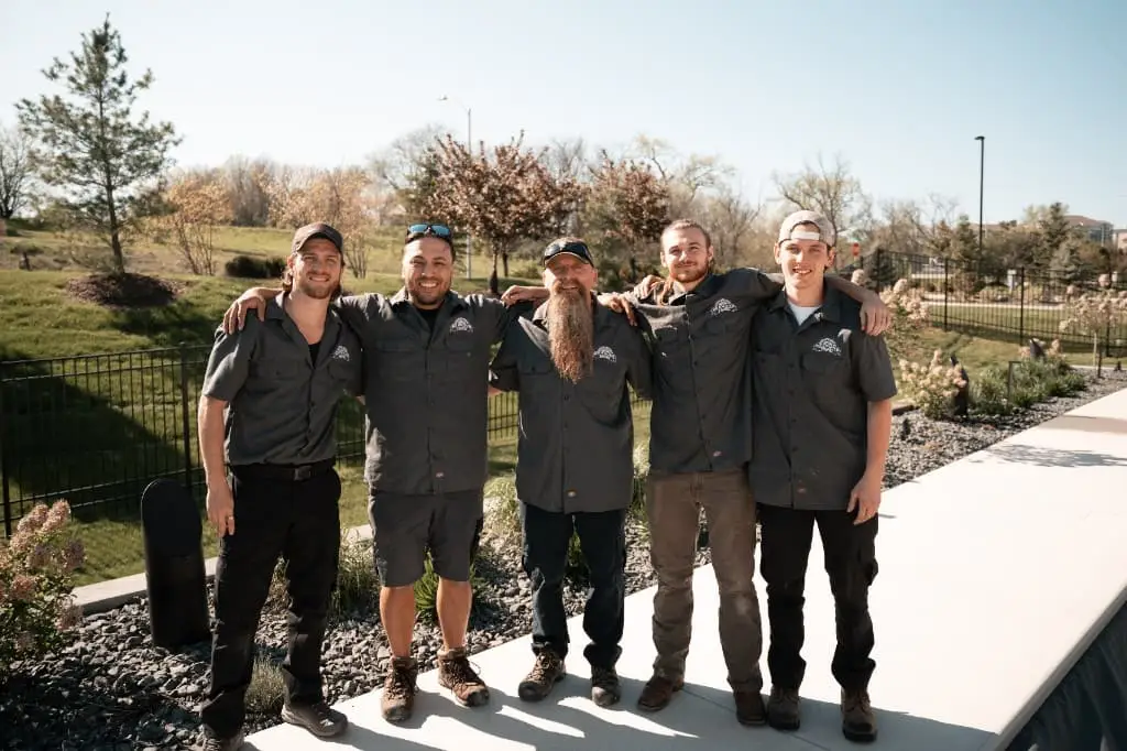 The All Seasons HVAC crew of five technicians in branded work shirts standing together outdoors